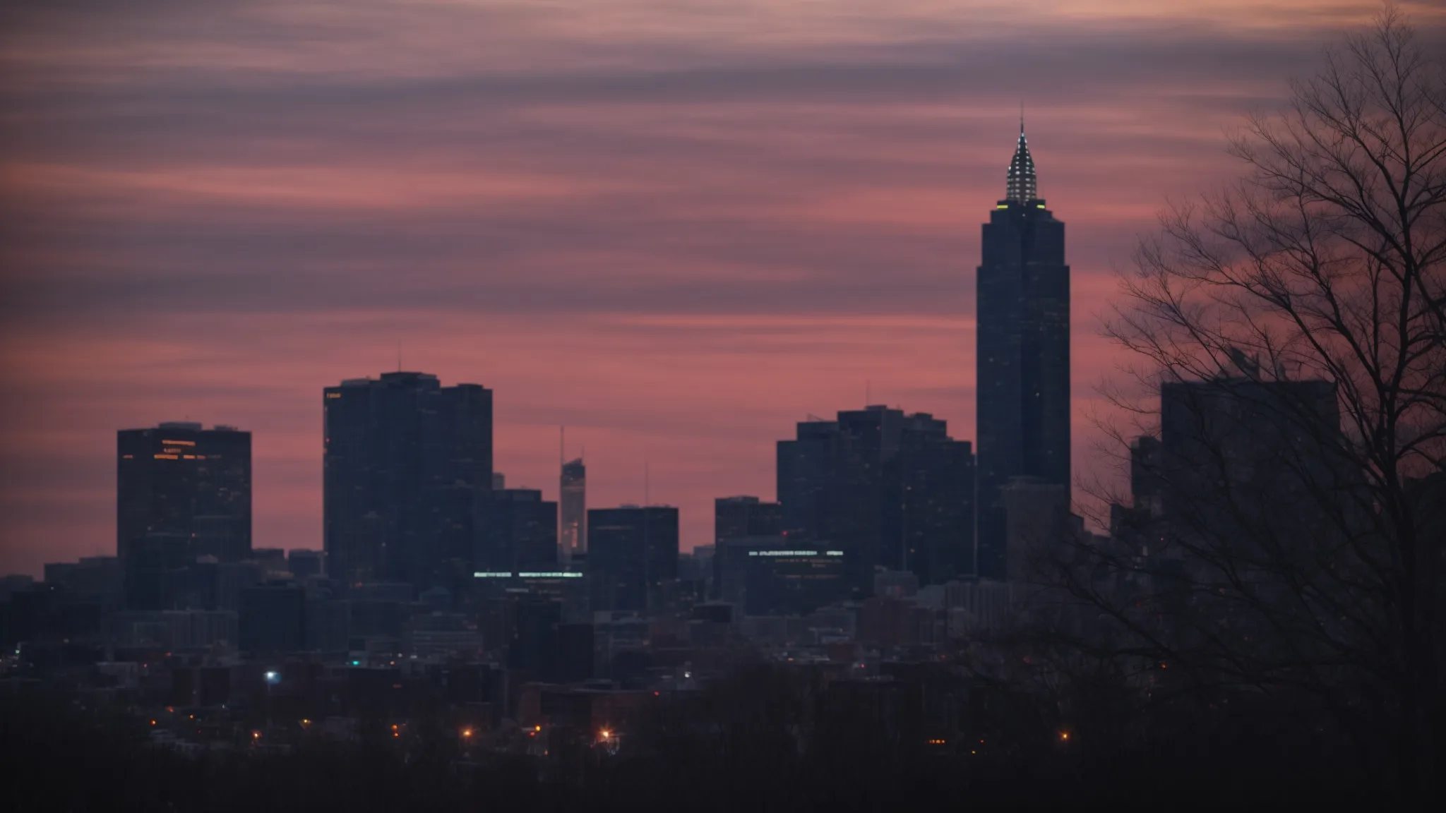 a skyline silhouette of indianapolis at dusk, highlighting the city's iconic structures under a vibrant sky.